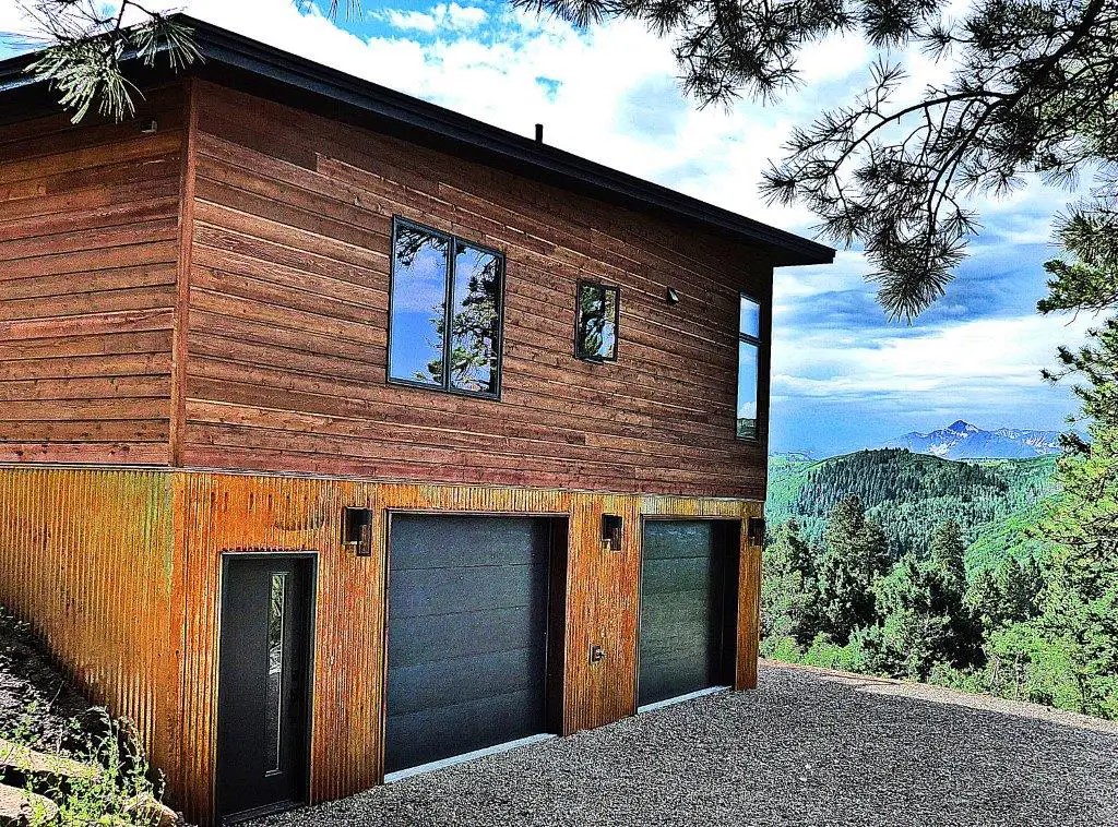 Aspen home with wood siding and two garage doors